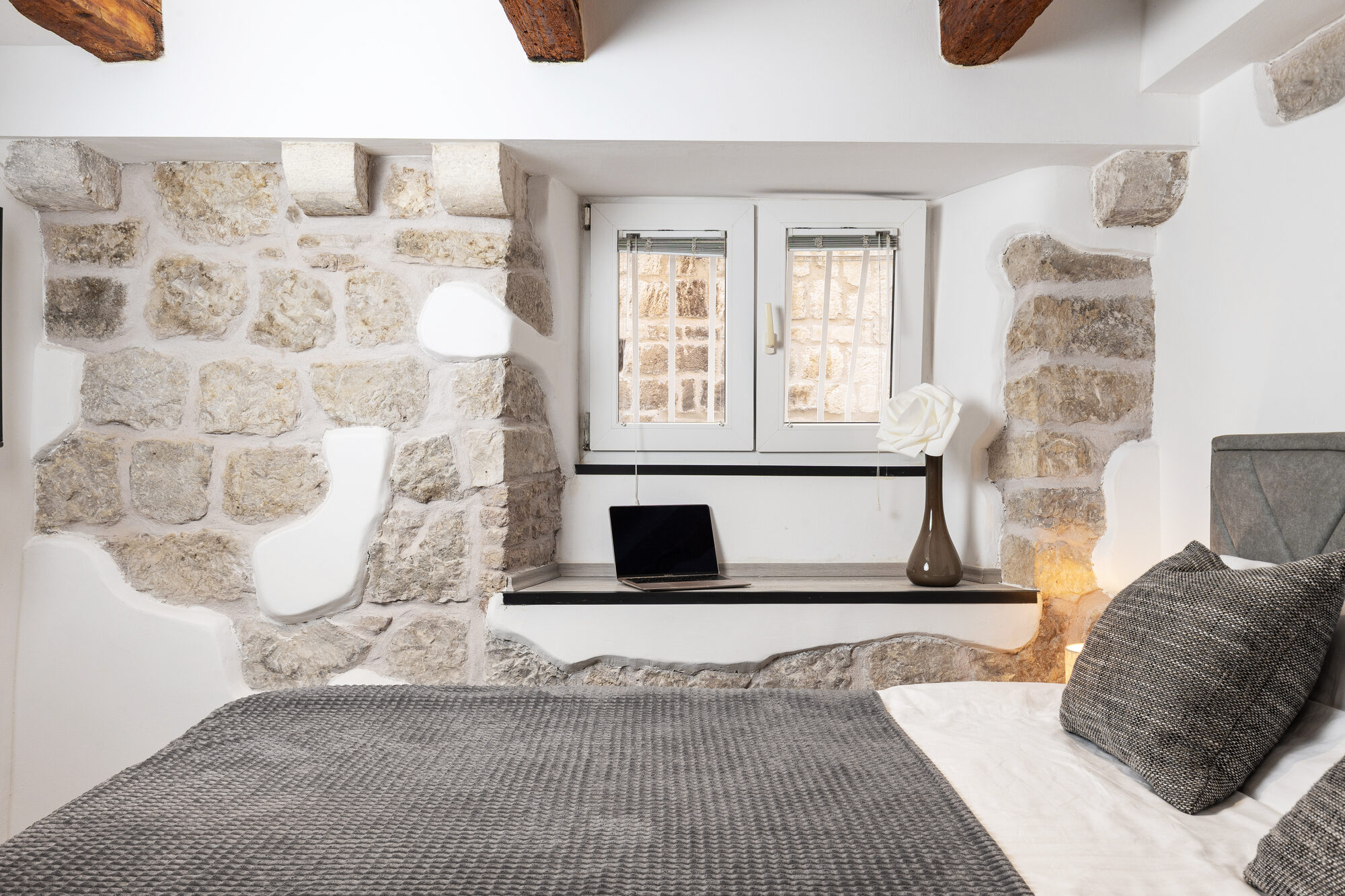 Window seat with laptop and stone walls